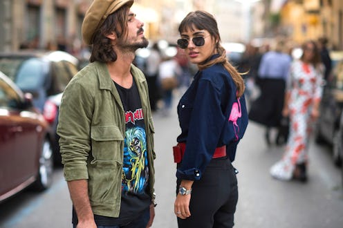 Two people who are dating stand in the street both with a distinct personal style