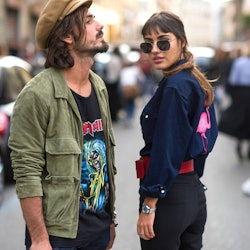 Two people who are dating stand in the street both with a distinct personal style