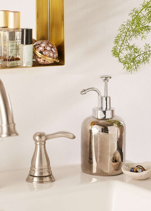 A silver bathroom soap pump next to a sink