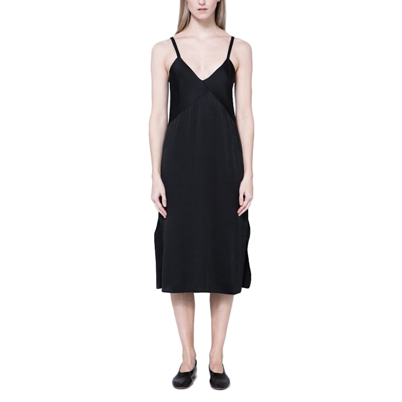 A model posing in a black slip dress