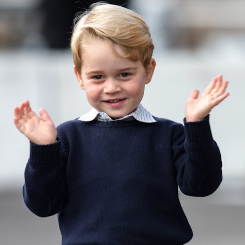 Prince George smiling and waving in a navy sweater and a light-blue shirt