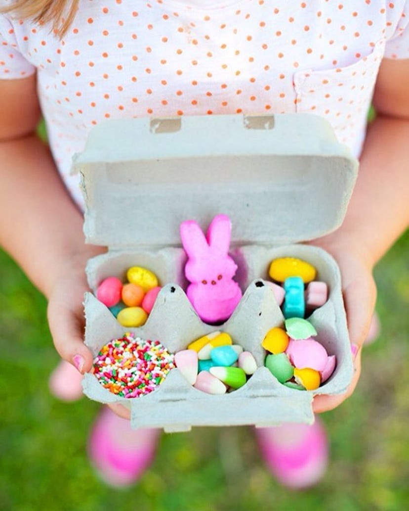 A kid holding a gift box filled with colorful candies