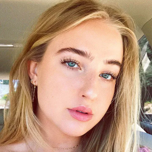 A blonde girl taking a selfie with mascara on her face