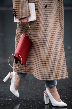 A woman in a brown check coat, white sling-back heels and a red statement bag every fashion girl sho...