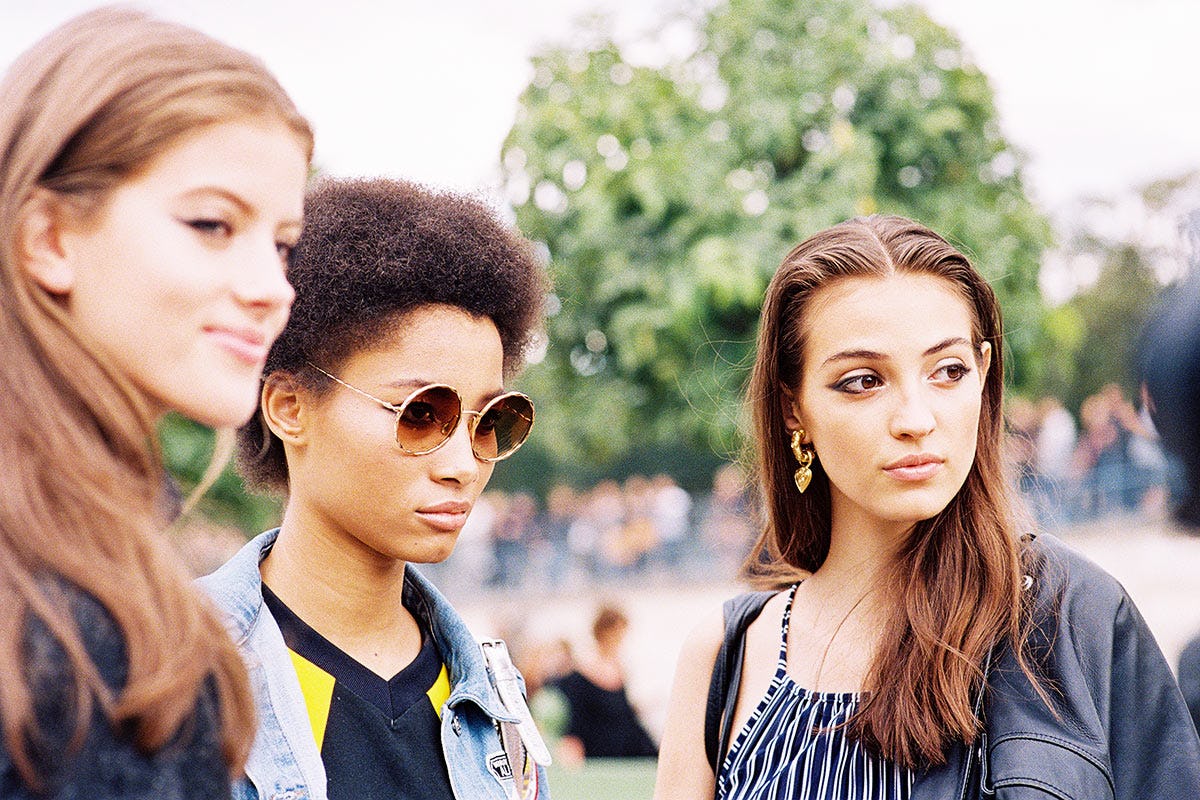 Three girls that hate sunscreen standing in a park
