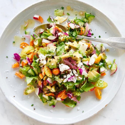 A plate of colorful salad with a healthy dressing