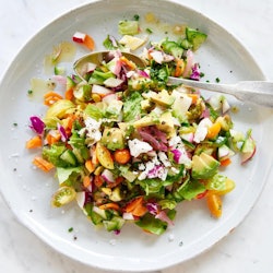 A plate of colorful salad with a healthy dressing