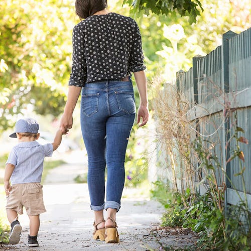 A woman walking while holding her son's hand