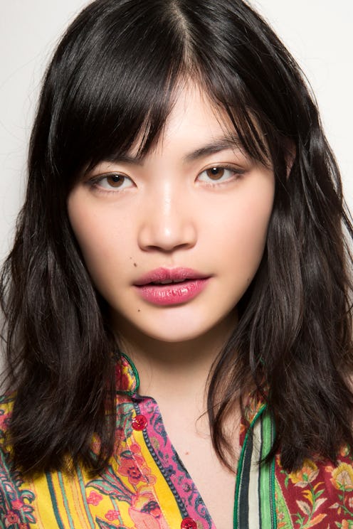 A model with minimal makeup and glowy skin due to the serum she uses