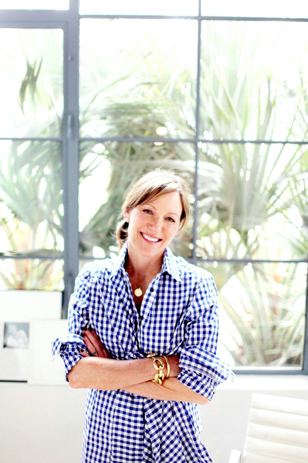 Beautycounter founder Gregg Renfrew  in a shirt dress and pulled back hair, smiling 