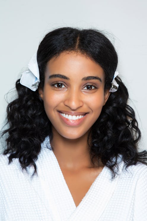 A young woman smiling with makeup on her face