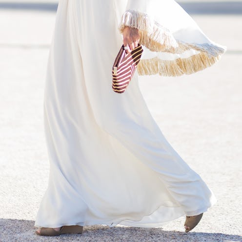 A woman holding a red and white makeup bag