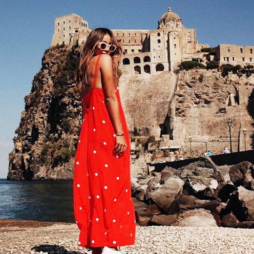 A young lady posing in a red summer dress and white sneakers