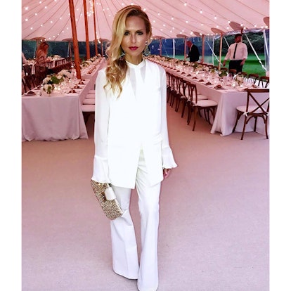 Rachel Zoe posing in a white suit while attending a dinner party