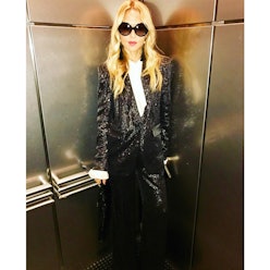 Rachel Zoe in a sparkly black suit and sunglasses in an elevator