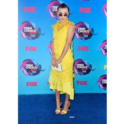 Millie Bobby Brown posing in a yellow dress at The 2017 Teen Choice Awards