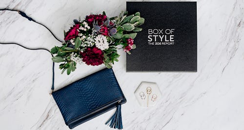 The Fall 2017 Box of Style, blue Convertible Clutch and a bouquet lined up next to each other on a m...
