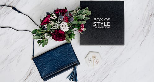 The Fall 2017 Box of Style, blue Convertible Clutch and a bouquet lined up next to each other on a m...