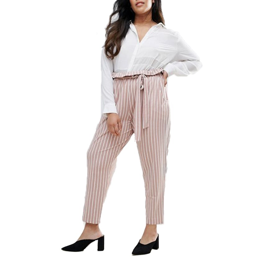 A black-haired model posing in peg pants with an oversized bow in stripe