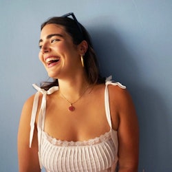 A model who is petite and plus-size laughing and looking to the side