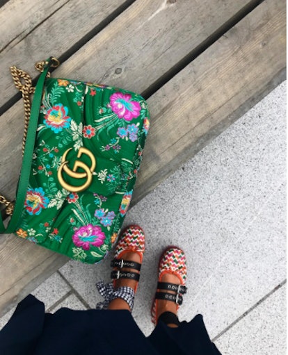 A green Gucci bag on a bench 