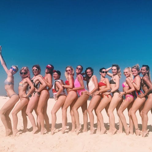 Cara Delevingne and her friends posing on the beach all turned to the side, looking at the camera