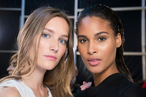 Two young ladies posing for a photo with beauty products on their faces