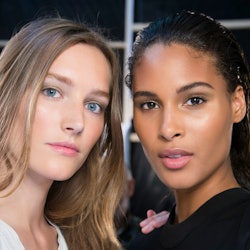 Two young ladies posing for a photo with beauty products on their faces