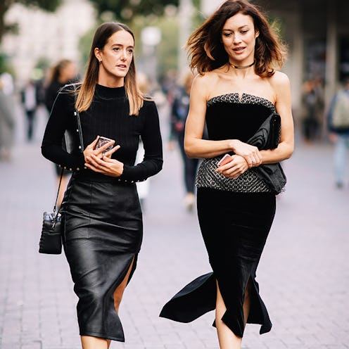 Two women wearing all-black outfits walking the street