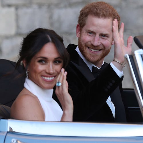 Harry and Meghan waving to people while sitting in a car on their wedding