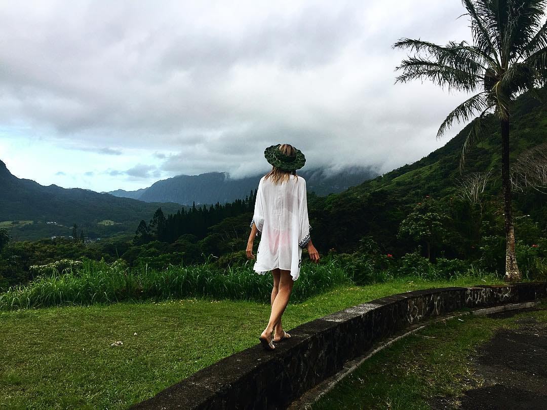 A blonde girl walking in a white cardigan at the Hawaiian Islands