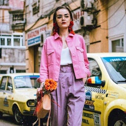 A model in a pink denim jacket and purple pants