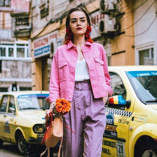 A model in a pink denim jacket and purple pants