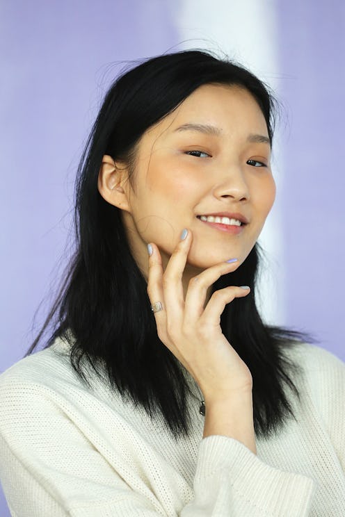 Young black haired lady posing for a photo in a white shirt