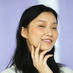 Young black haired lady posing for a photo in a white shirt
