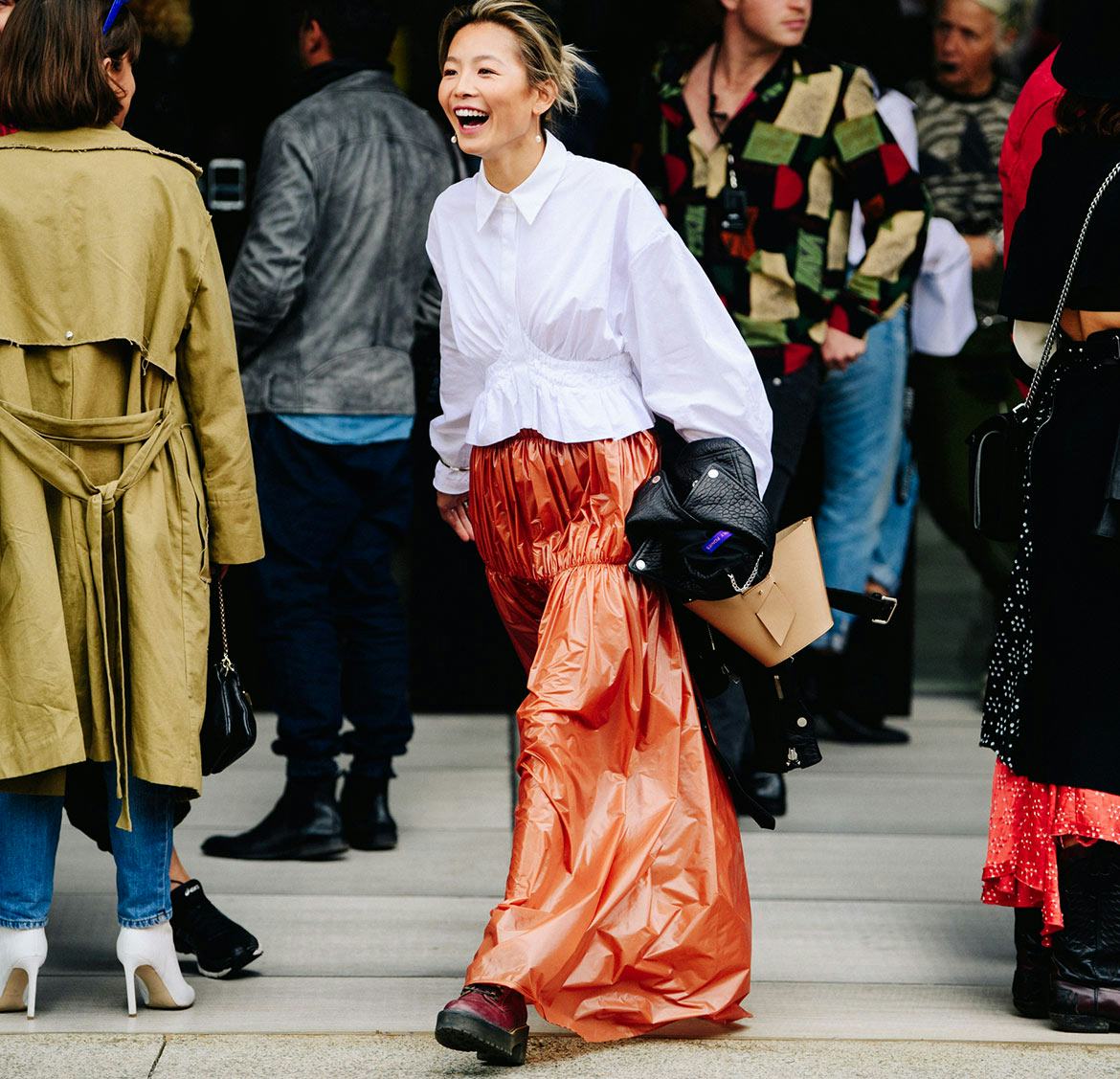 A woman in a white shirt, and an orange satin skirt from the chic Asian brands