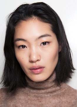 Asian model promoting makeup removal as an essential step of your beauty routine.