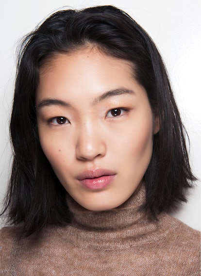 Asian model promoting makeup removal as an essential step of your beauty routine.