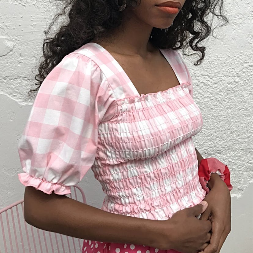 A girl wearing a pink and white plaid top