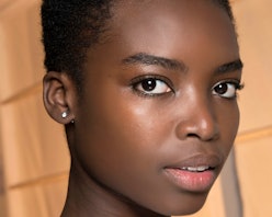 Full-profiled girl posing with toner on her skin face