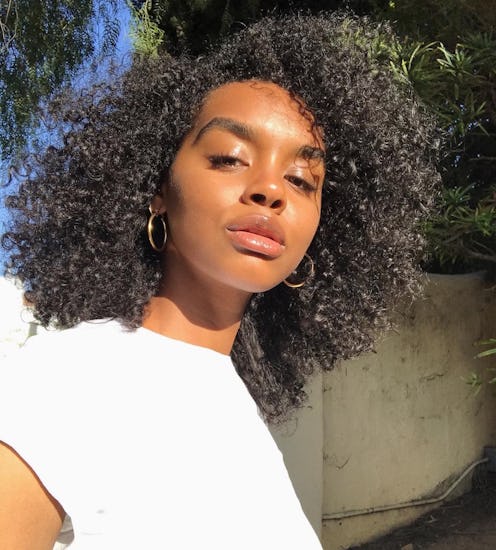 A woman posing in a white top during the summer with sweatproof foundation applied