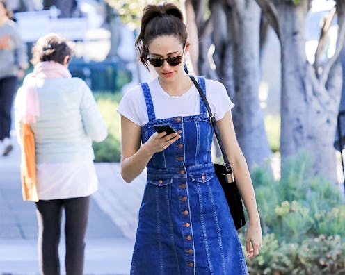 A woman in a white T-shirt and a denim dress