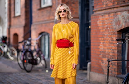 A woman in a yellow dress and an orange belt bag that is chic and convenient