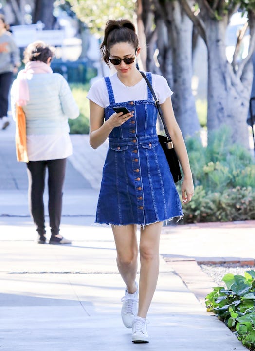 A woman in a white T-shirt and a denim dress